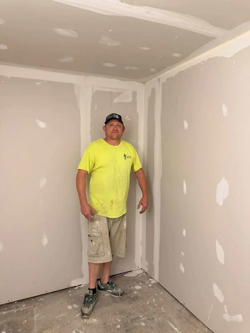 Jeremy Girard, owner of The Original Patch Master, standing in a room of hung drywall